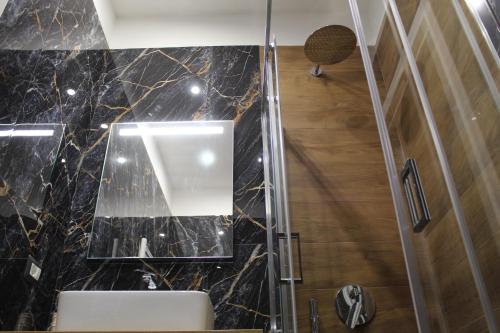 那不勒斯BlackWoody Contemporary Rooms - Napoli Centro Storico的浴室设有水槽和墙上的镜子