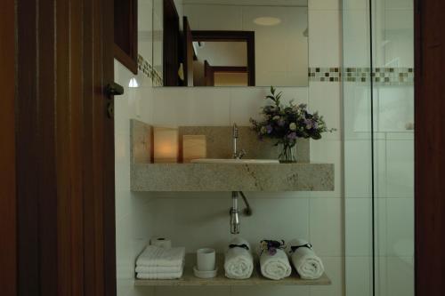 巴拉-沙希Vila dos Caetés - Suíte 03 - Barra do Sahy的浴室配有盥洗盆、镜子和毛巾