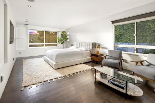 洛杉矶Hollywood Hills Luxury Modern Home with Pool & Sunset views的一间卧室配有一张床、一张沙发和椅子