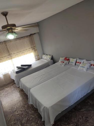 洛马斯-德萨莫拉Dakini Hostel的一间卧室设有两张床和窗户。
