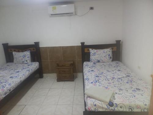 卡塔赫纳hotel casa del conductor doña silvia的一间设有两张床和床头柜的房间