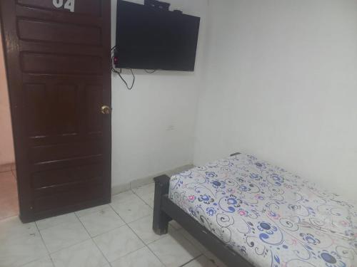 卡塔赫纳hotel casa del conductor doña silvia的一间卧室配有一张床和一台平面电视