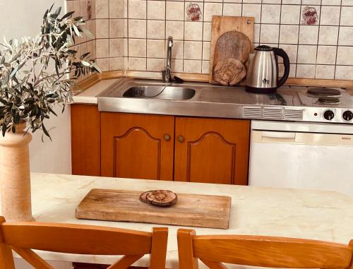 阿莫皮Studios Fokia Beach的厨房配有水槽和桌椅