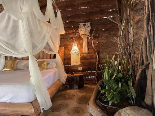 Villa Florwellgaya ecovillas的小木屋内一间卧室,配有一张床