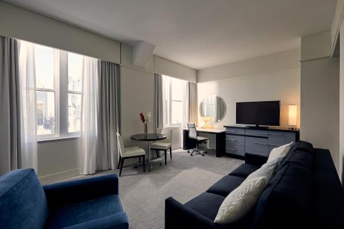 费城洛伊斯费城酒店的客厅配有沙发和带电视的桌子