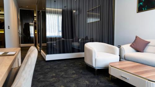 莫斯塔尔HA Hotel Mostar的客厅配有沙发和椅子