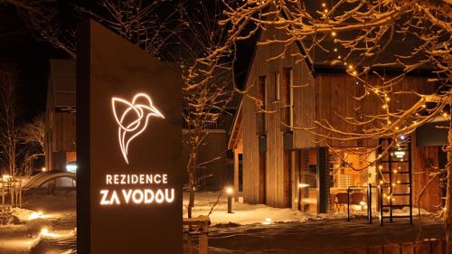 切尔尼杜尔Rezidence Za Vodou - Ledňáček的夜间雪地里餐厅的一个标志