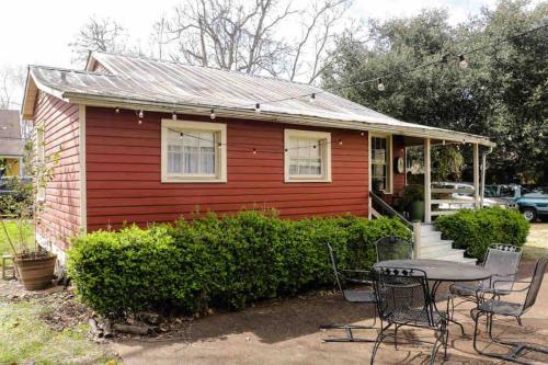 纳奇兹Wensel Cottage in downtown Natchez的一间红色的小房子,前面有一张桌子