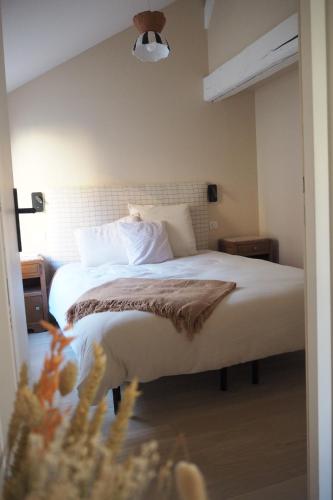 格勒诺布尔Les baleines - hypercentre 2 chambres avec garage et clim - air conditioning的一间卧室配有带白色床单和枕头的床。