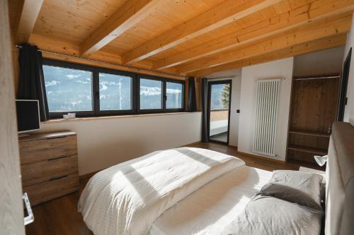 卡瓦莱塞MOUNTAIN DELUXE 27 APARTMENTS的一间设有床铺的卧室,位于带窗户的房间内