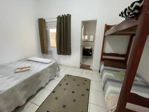 坎普斯戈伊塔卡济斯Status Casa Pelinca的一间卧室配有两张床和一张双层床。