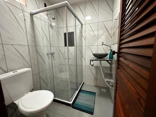 彼得罗波利斯Village Hostel的一间带卫生间和玻璃淋浴间的浴室