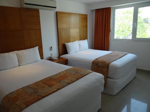 坎昆盖比套房酒店的酒店客房设有两张床和窗户。