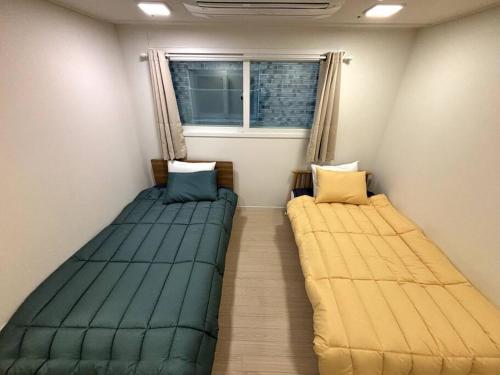首尔Clean 2 SuperSingle Beds House的两张床位于带窗户的房间内