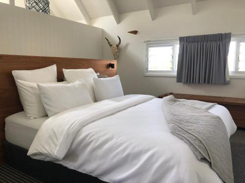 黄金海岸Indigo Charlee的一张白色大床,配有白色床单和枕头