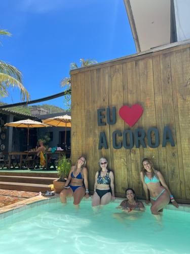 阿拉亚尔-杜卡布A Coroa Hostel & Suites的度假村游泳池的4名女性