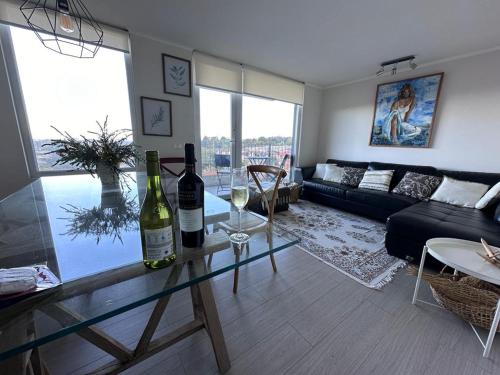 巴拉斯港Hermoso depa的客厅配有玻璃桌,提供两瓶葡萄酒