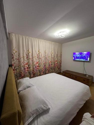 图尔恰LukApartaments的卧室配有一张白色大床和电视。