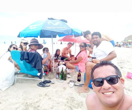 洛斯拉甘斯Casa Entre Rocas y Veleros的一群人坐在沙滩上