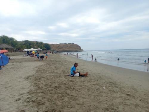 洛斯拉甘斯Casa Entre Rocas y Veleros的一群人坐在海滩上的人