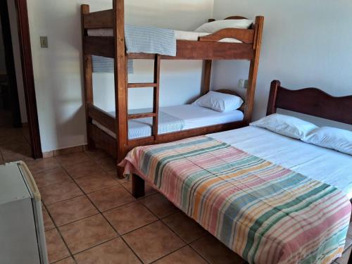 乌巴图巴Pousada Sol da Lagoinha的一间卧室配有两张双层床和一张床