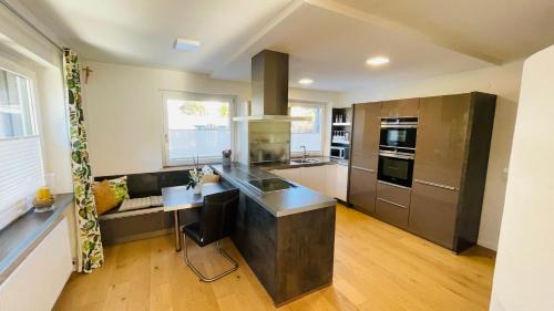 布鲁克安德格罗斯哥Kohlis Alpine Home的一间铺有木地板并配有不锈钢用具的大厨房