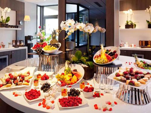 巴黎巴黎凡尔赛门展览中心美居酒店的一张桌子上放着许多盘子的食物