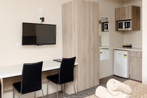 Miles斯塔林汽车旅馆的厨房配有桌椅和电视。