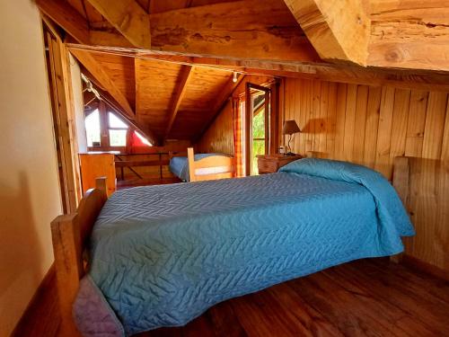 特来凡林Posada El Maiten的小木屋内一间卧室,配有一张床