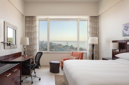 乔治敦圭亚那乔治敦万豪酒店的配有一张床、一张书桌和一扇窗户的酒店客房