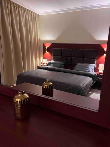 奥朱贝尔شقة سكنية بغرفتين نوم的一间卧室配有一张大床和大镜子