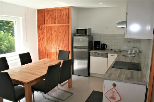 特里贝格Haus am Waldrand的厨房配有桌椅和冰箱。