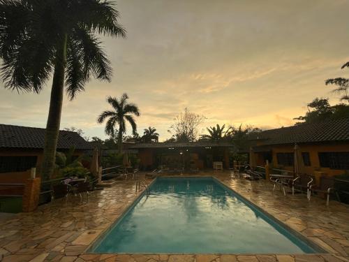 坎布里Camburi Chalés的一个带椅子的游泳池,并种植了棕榈树