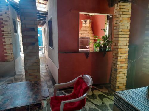 卡希亚斯公爵城Meu Quarto no Rio de Janeiro的一张红色椅子,放在带桌子的房间