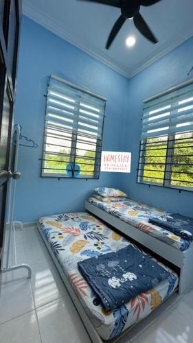 丹那美拉Homestay Mohd Aizri Bukit Gading的配有两张床铺的蓝色墙壁和窗户