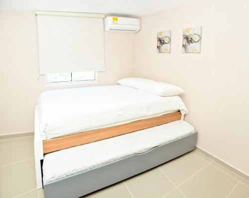 巴兰基亚Excelente ubicación y cómodo apto, perfecto para ti!的一间卧室设有两张床和窗户。
