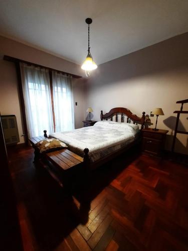 内科切阿Casa a 2 cuadras de la playa的一间卧室设有一张大床,铺有木地板