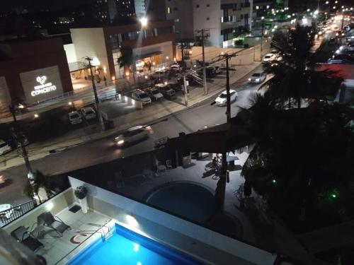 萨尔瓦多Apartamento em Salvador的享有大楼的景色,在晚上设有游泳池