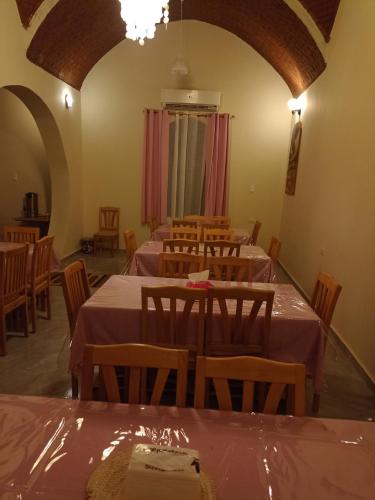 Qasr Al FarafirahRahala Safari Hotel的用餐室配有桌椅和粉红色的桌布