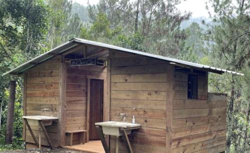 ManabaoSpirit Mountain Coffee的一座带两个水槽的小型木制建筑