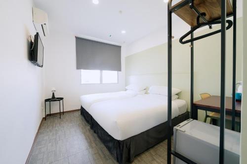 马六甲The Concept Hotel Melaka City的一间卧室配有一张床和一张双层床。