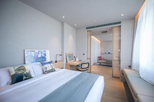 北京念念行旅酒店(北京南锣鼓巷北新桥地铁站店)的卧室配有一张白色大床和一张书桌