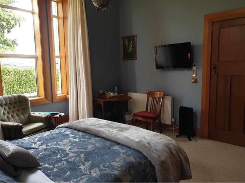 WintonBelvedere Bed & Breakfast的卧室配有一张床,墙上配有电视。