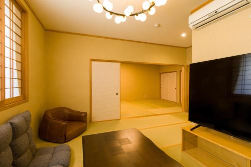 东京Himalaya Cloud Hotel的客厅配有平面电视和沙发。
