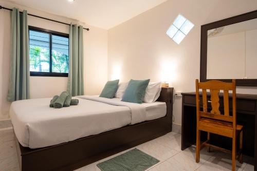 Phra Ae beachLanta School Beach Resort的一间卧室配有一张带桌子和椅子的床