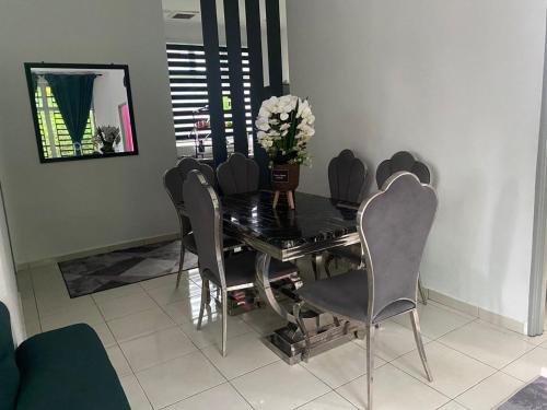 居林Creatills luxury homestay Kulim & hi-tech的餐桌、椅子和花瓶