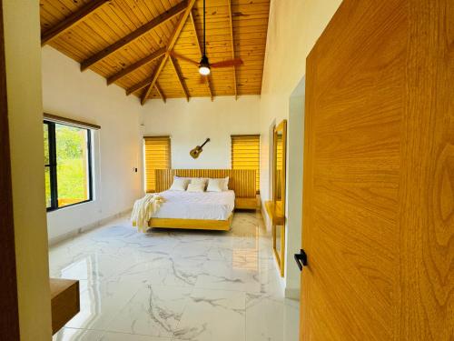 哈拉瓦科阿The Grand Chalet的一间卧室设有一张床和木制天花板