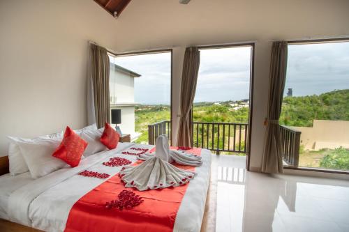 金巴兰金巴兰海景别墅的一间卧室配有一张带红色枕头的大床