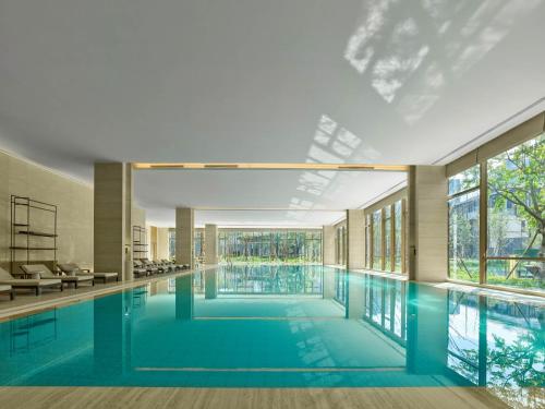 东莞东莞松山湖悦榕庄的一座大型游泳池,位于一座带窗户的建筑内