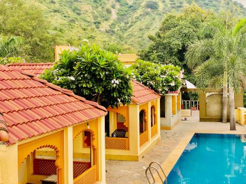 乌代浦Udai Nature Valley Resort by AN Hotels-A Peacefull river Retreat的一座带游泳池的别墅,毗邻一个度假胜地
